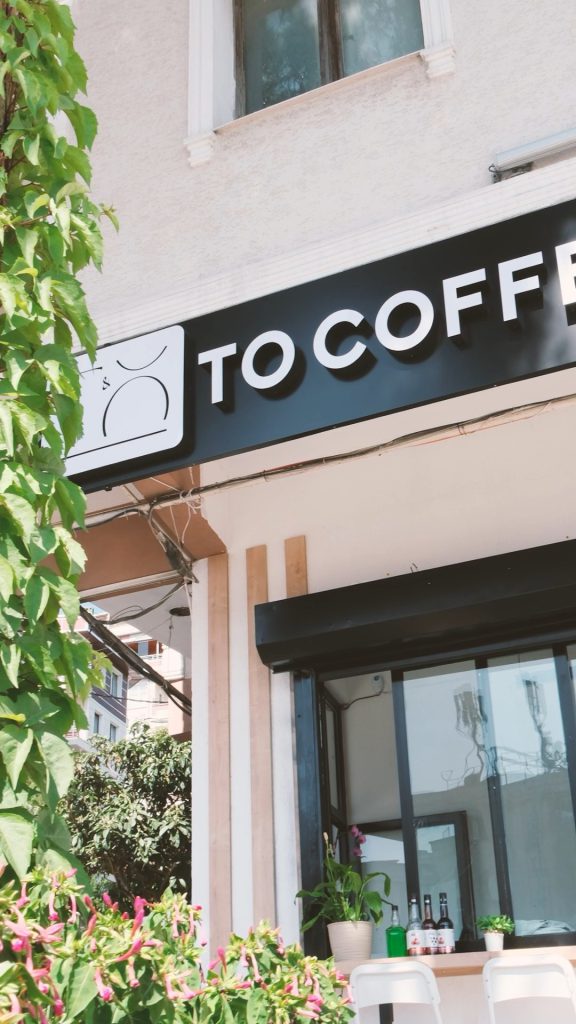 To Coffee tabelası ve sarmaşıklarla çevrili giriş cephesi